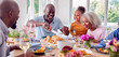 © Monkey Business - Grandfather Carving As Multi Generation Family Sit Around Table At Home And Enjoy Eating Meal