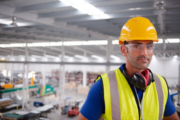 Poster - Portrait serious male worker in protective eyewear and hard-hat in factory