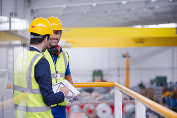 Supervisor and worker talking in steel factory