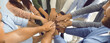 Team of business people who work together joining hands. Teamwork themed banner background with group of colleagues standing in circle and stacking hands. Concept of union, teamwork and partnership