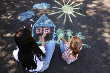 Canvas Print - Little child and her mother drawing with colorful chalks on asphalt, above view