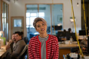 Portrait of young woman in office, smiling