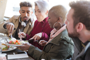 Portrait of smiling friends eating at restaurant outdoor patio