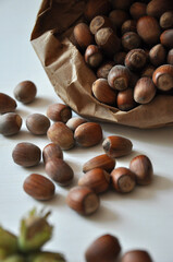 Wall Mural - Hazelnut close-up. Hazelnuts in a paper bag on a wooden background. Hazelnut background, healthy food. Corylus. 