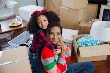 Portrait happy mother and child taking a break from moving