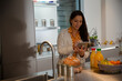 © KOTO - Woman with digital tablet at refrigerator in kitchen