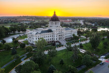 South Dakota State Capitol Building In Pierre, SD. Aerial Drone View At Sunrise With Golden Glow Behind Domed Roof.
