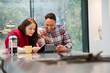 © KOTO - Couple financial planning at digital tablet in kitchen
