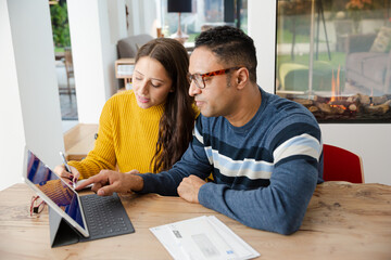 Couple paying bills online, using fingerprint log on at digital tablet