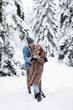 © Di Studio - full length portrait of happy couple in winter forest warming up with hot drink