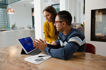 Couple paying bills online, using fingerprint log on at digital tablet