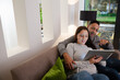 © KOTO - Couple relaxing, using digital tablet on living room sofa