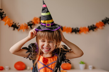 Portrait of little girl dressed Halloween witch costume and hat