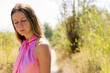 © URI - Young caucasian girl with pink top smiling with closed eyes on a footpath