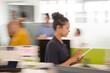 © KOTO - Businesswoman using tablet computer in open plan office