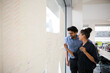 © KOTO - Business people discussing diagram sketches hanging on office window