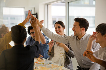 Wall Mural - Happy business people touching hands, celebrating success with sushi lunch