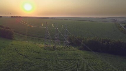 Wall Mural - Transmission line in rural field. High-voltage tower for electrical grid in aerial view