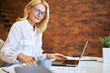 © Kostiantyn - Attractive mature businesswoman in glasses using laptop and doing some paperwork at the office