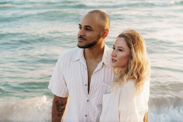 Wall Mural - Young happy couple on seashore enjoying the sea