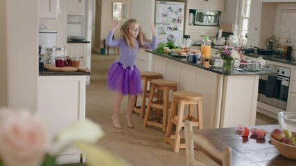 happy ballerina girl dancing in kitchen wearing purple tutu having fun performing funny dance moves 
