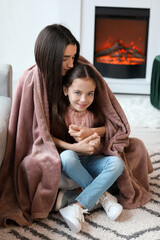 Sticker - Young mother and daughter resting near fireplace at home