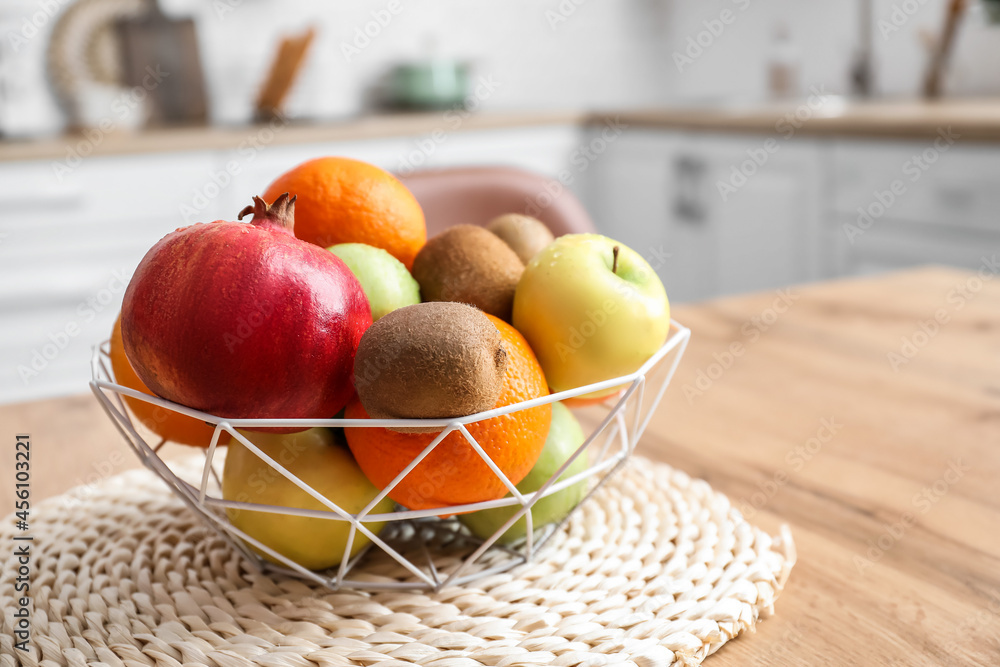 Basket with fresh fruits on table in kitchen, closeup