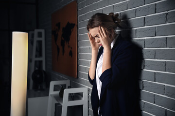 Poster - Young depressed businesswoman in dark office