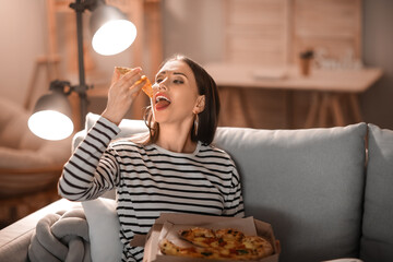 Poster - Beautiful young woman eating tasty pizza at home in evening