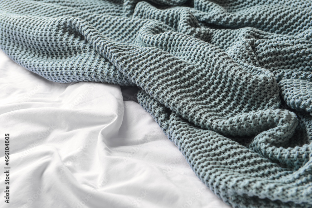 Knitted plaid on bed, closeup