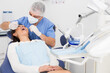 © JackF - The dentist in face mask inspects female patient teeth with mirror and probe