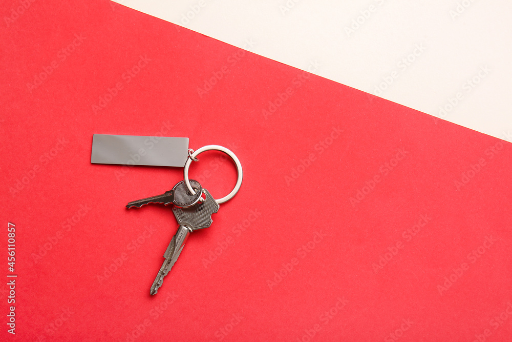 Keys with stylish keychain on color background