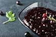 © Pixel-Shot - Bowl with black currant jam on dark background