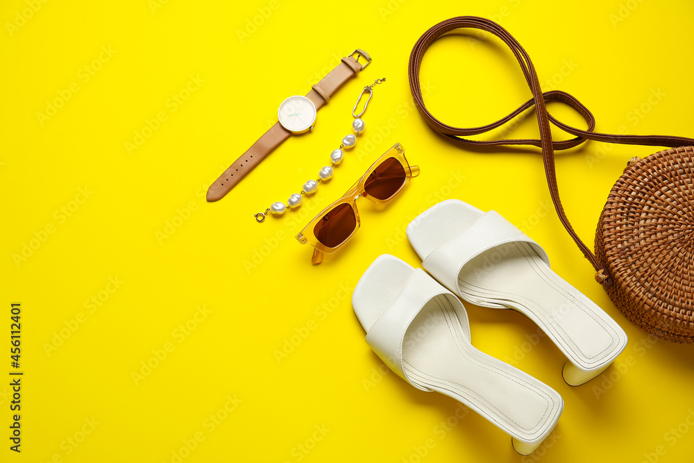 Female shoes and stylish accessories on color background