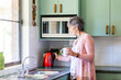 © Austockphoto - Senior woman using a jug to boil water and make a cup of tea