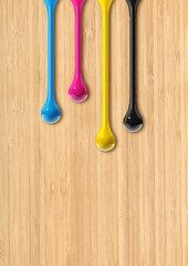 Wall Mural - cmyk ink drops on beige wooden background
