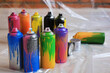 © New Africa - Used cans of spray paints on floor indoors. Graffiti supplies