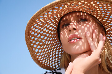 Poster - Beautiful woman with straw hat against blue sky on sunny day