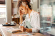 © (JLco) Julia Amaral - Entrepreneur looking stressed while doing her budget in her cafe