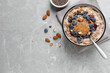 © New Africa - Tasty oatmeal porridge with toppings served on grey table, flat lay. Space for text