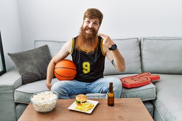 Poster - Caucasian man with long beard holding basketball ball cheering tv game smiling cheerful showing and pointing with fingers teeth and mouth. dental health concept.