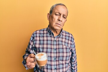 Sticker - Handsome senior man with grey hair drinking a cup coffee looking sleepy and tired, exhausted for fatigue and hangover, lazy eyes in the morning.