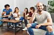 © Krakenimages.com - Group of young friends having party sitting on the sofa at home. Man smiling happy talking on the smartphone at home.