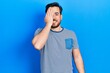 © Krakenimages.com - Handsome caucasian man with beard wearing casual striped t shirt covering one eye with hand, confident smile on face and surprise emotion.