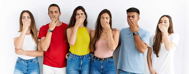 Canvas Print - Group of people wearing casual clothes standing over isolated background bored yawning tired covering mouth with hand. restless and sleepiness.