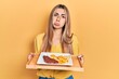 © Krakenimages.com - Beautiful hispanic woman holding tray with meat loaf and fried egg depressed and worry for distress, crying angry and afraid. sad expression.