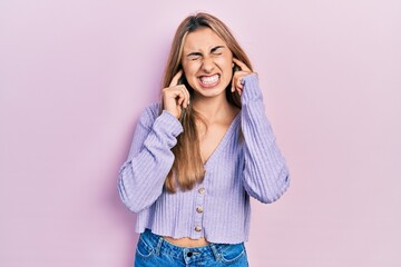 Poster - Beautiful hispanic woman wearing casual shirt covering ears with fingers with annoyed expression for the noise of loud music. deaf concept.