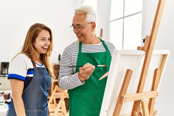 Poster - Middle age paint teacher and student smiling happy painting at art studio.