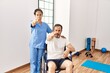 © Krakenimages.com - Hispanic middle age man sitting on wheelchair and nurse at rehabilitation clinic pointing with finger to the camera and to you, confident gesture looking serious