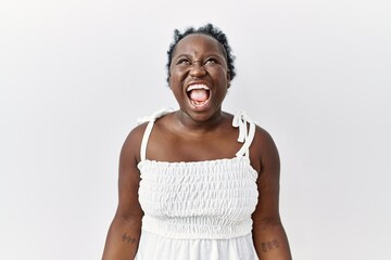 Sticker - Young african woman standing over white isolated background angry and mad screaming frustrated and furious, shouting with anger. rage and aggressive concept.